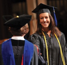 Graduate shaking hands while receiving diploma