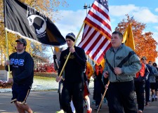 Cadets running through campus holding flags