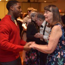 A young male student and older female promgoer cut it up on the dance floor.