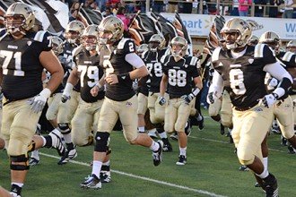 Photo of WMU football team running onto the field.