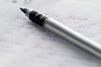 Photo of a pen on a page full of handwritten notes.