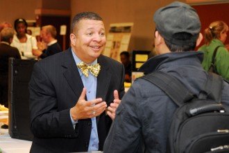 Photo of a staff member speaking with a student at a career fair.