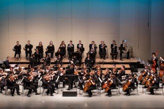 Photo of musicians from the WMU Symphony Orchestra performing on a stage.