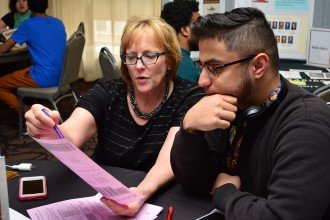 An advisor assists an international student during walk-in advising hours
