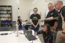 Photo of student and faculty researchers at the College of Engineering looking at laptops. 