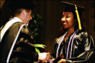 Photo of WMU President John M. Dunn congratulating a graduate.