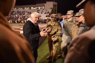 James McCloughan stands on the field at Waldo Stadium chatting with Army ROTC cadets.