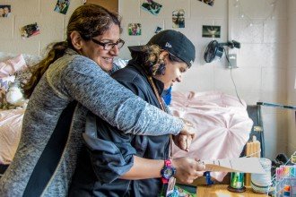 A mom embraces her child, a student at WMU, as they hang out together in the dorms.