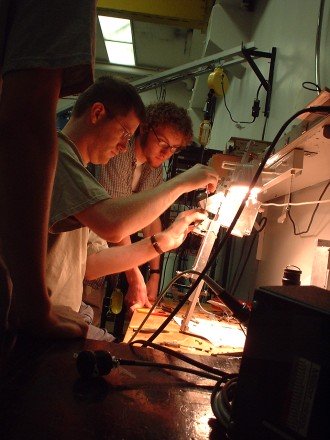 A WMU physics postdoc and graduate student building an instrument for their experiment.