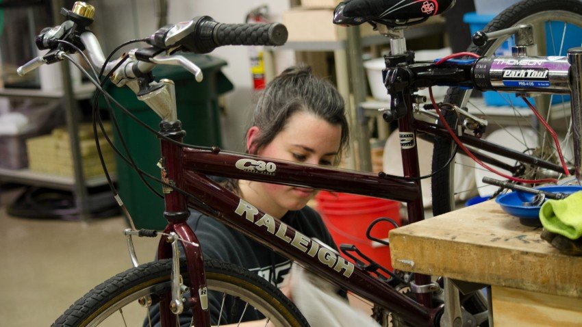 Woman wiping the frame of her maroon bike