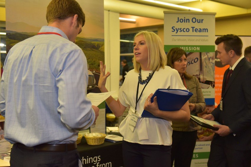 Students and Sysco Corp. reps interact during a marketing career fair.teract during a marketing career fair.